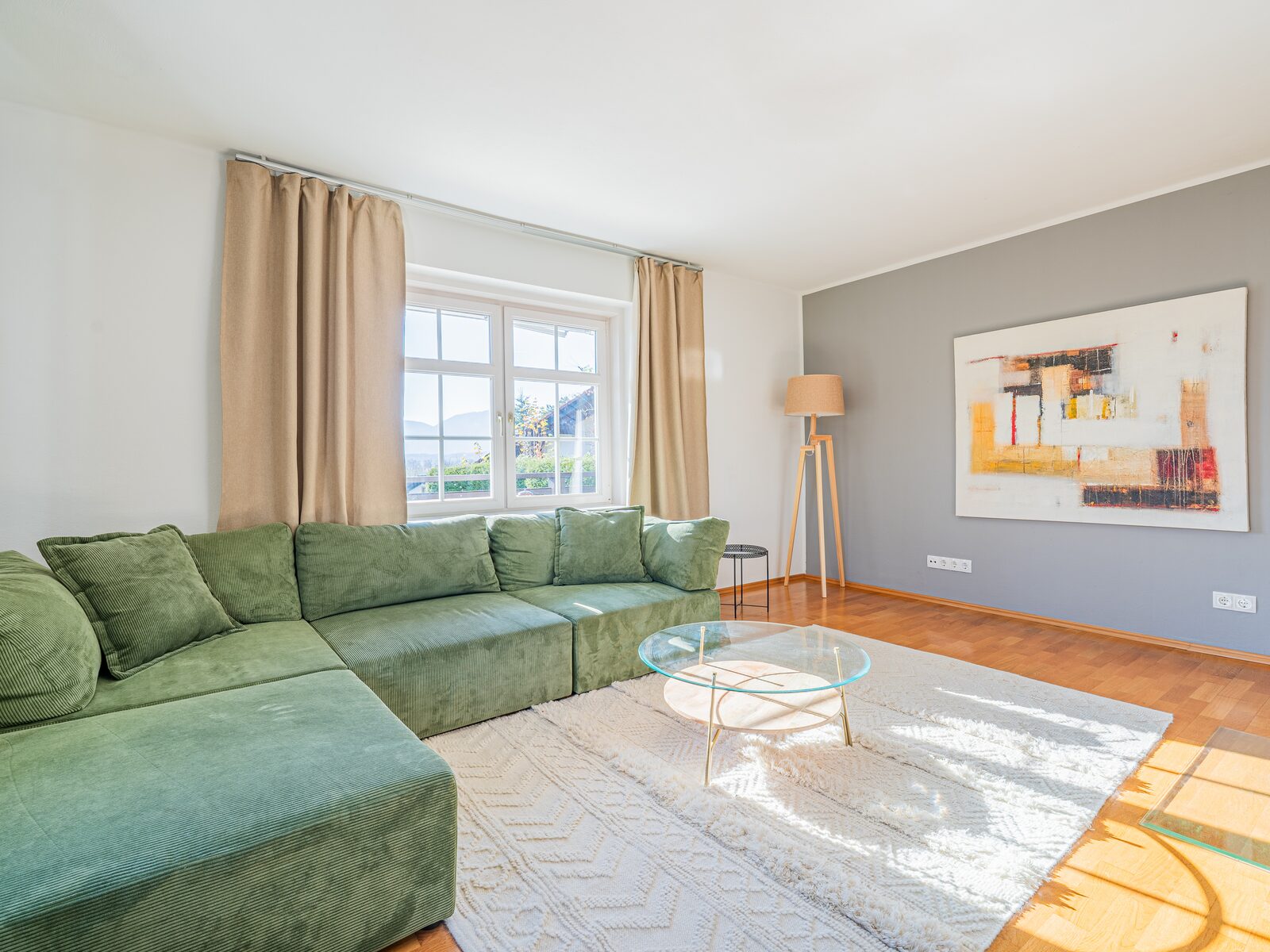 Living room of one of our holiday apartments with a green sofa